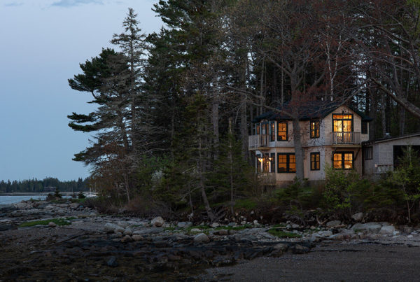 The Claremont Hotel’s ALM Cottage set against trees and overlooking the beach.
