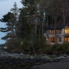 The Claremont Hotel’s ALM Cottage set against trees and overlooking the beach.